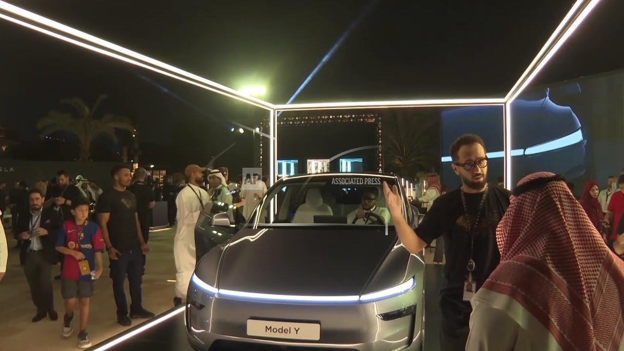 Guest takes photos of Tesla Model Y during its display in Riyadh after Tesla completes first fully autonomous Model Y delivery ahead of schedule