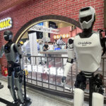 Two humanoid robots standing outside the WAIC shop, symbolizing the emerging future of the humanoid robot sector.