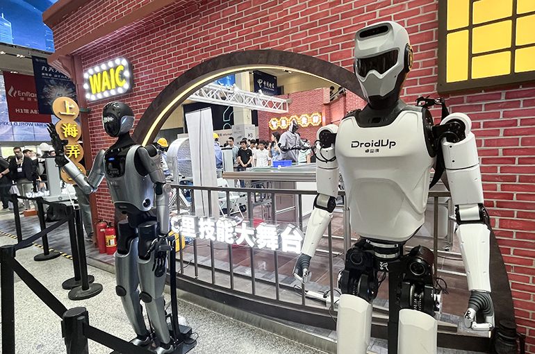 Two humanoid robots standing outside the WAIC shop, symbolizing the emerging future of the humanoid robot sector.