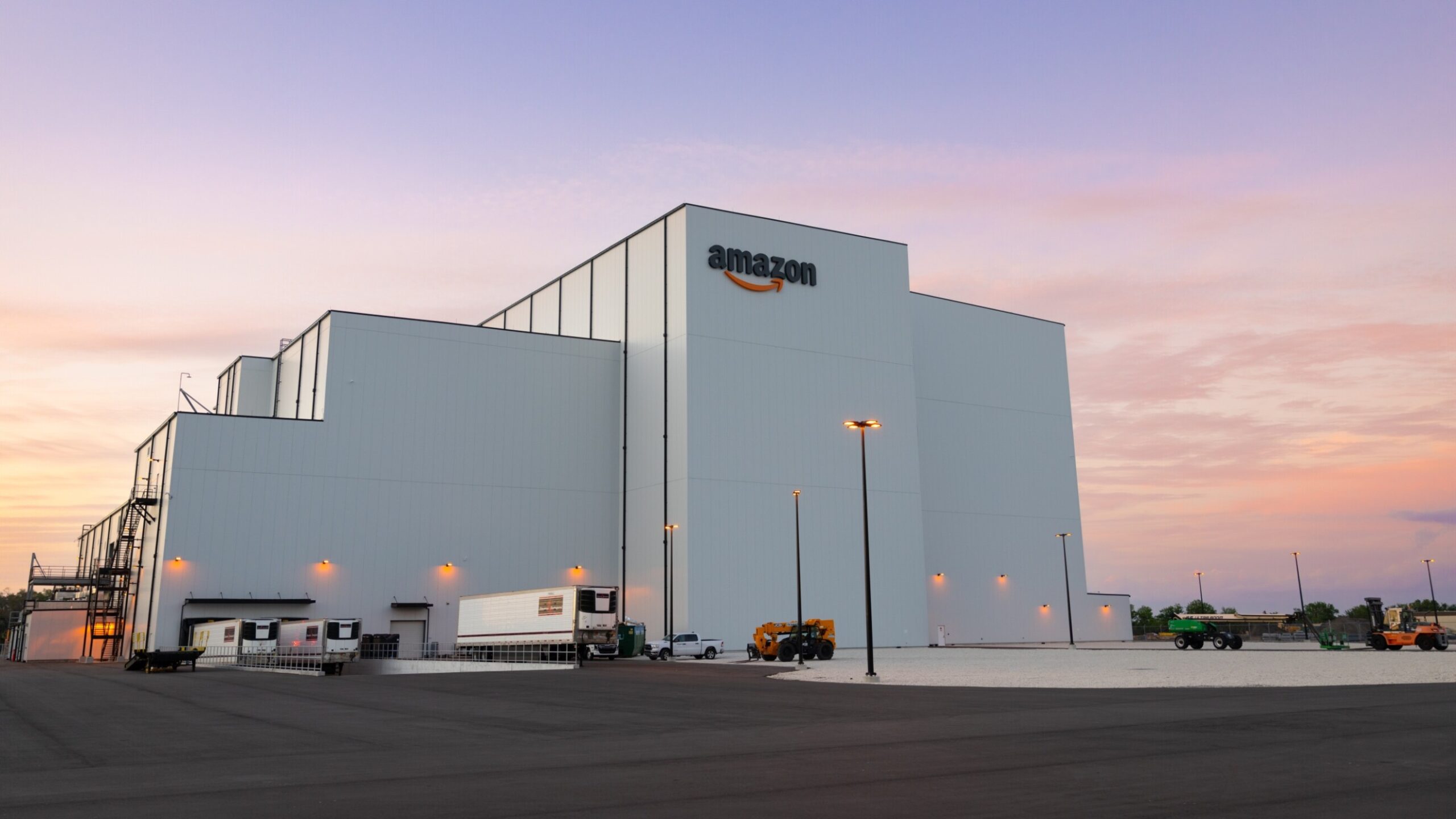 Modern Amazon satellite facility at sunset — exterior view of Project Kuiper’s Florida hub at Kennedy Space Center.