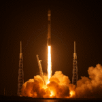 A Falcon 9 rocket launching 28 Starlink satellites into orbit from Cape Canaveral at night, with fiery exhaust and smoke clouds visible.