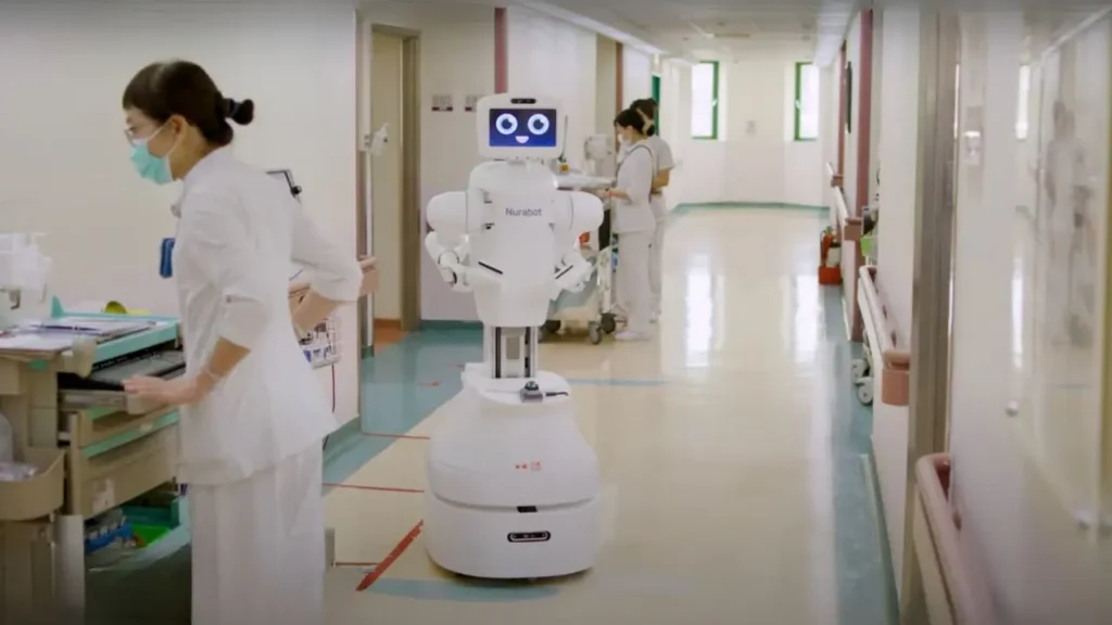 Kawasaki Foxconn Robot assisting hospital nurse with patient care.