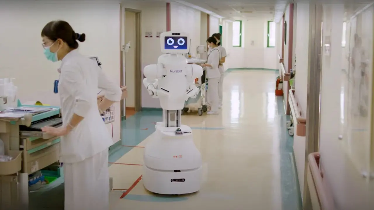 Kawasaki Foxconn Robot assisting hospital nurse with patient care.