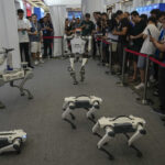 A group of DEEP Robotics' embodied intelligence robots performing a live demo at WAIC 2025 with a crowd watching
