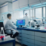 Scientist analyzing molecular structures on a computer screen in a high-tech lab during the CuspAI funding breakthrough.