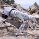 A mechanical robotic dog by Unitree navigating rocky terrain, symbolizing rising innovation behind Chinese robot stocks.