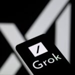 Close-up of Grok AI logo on smartphone screen with X (Twitter) logo blurred in the background, highlighting upcoming ads on Grok.