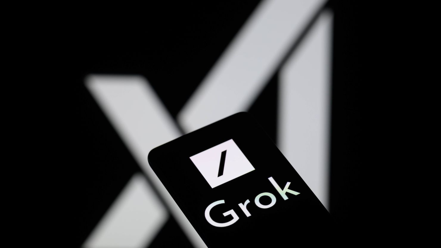 Close-up of Grok AI logo on smartphone screen with X (Twitter) logo blurred in the background, highlighting upcoming ads on Grok.