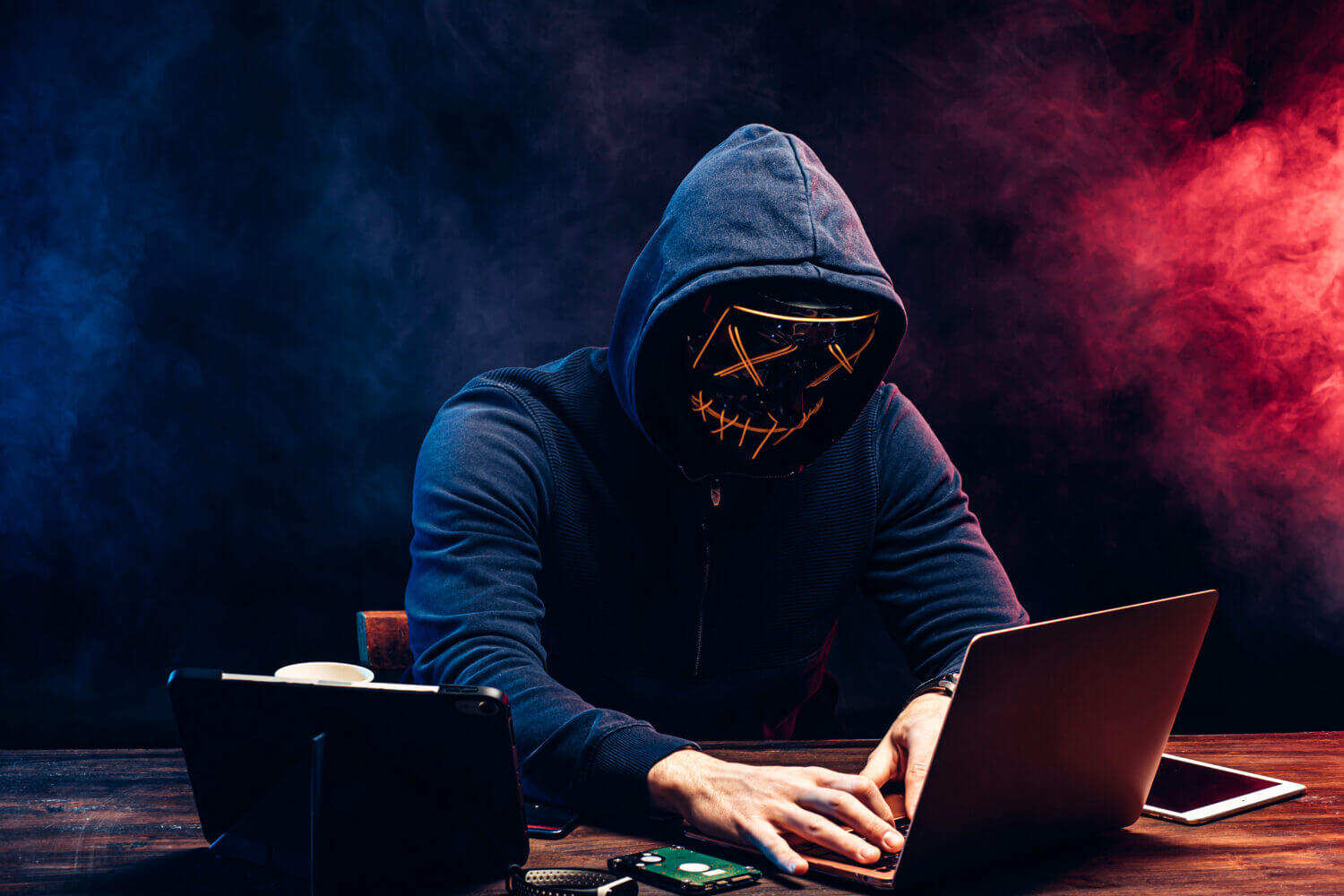 A hacker in a dark hoodie using a laptop with Google’s logo, warning signs, and a locked folder icon, symbolizing the recent security breach where Google has been hacked and user data stolen.