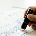 Office desk in Japan with fax machines and personalized ink stamps used for official documents.