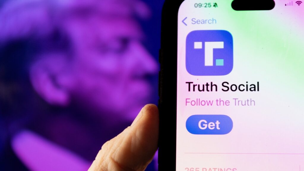 Close-up of a smartphone screen showing the Truth Social app download page, with a blurred image of Donald Trump in the background, highlighting the Truth Social AI chatbot contradictions.