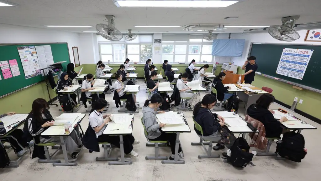 South Korean students in a classroom after AI rollback in classrooms, highlighting the shift from digital textbooks back to traditional learning.