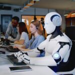 Humanoid robot working alongside human employees in a modern office, highlighting the AI job threat in customer service roles.