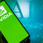 A smartphone screen displaying the Nvidia logo with AI background, representing Nvidia earnings as the next big test for the AI rally.