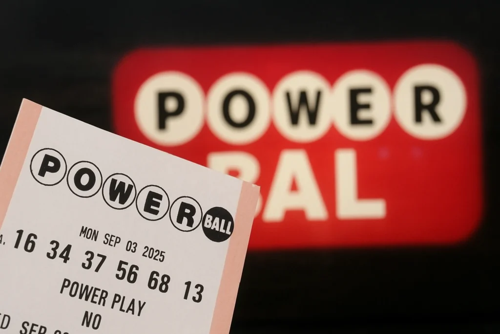 A Powerball lottery ticket held in front of a glowing Powerball sign, symbolizing the Powerball $2 million winner announcement.
