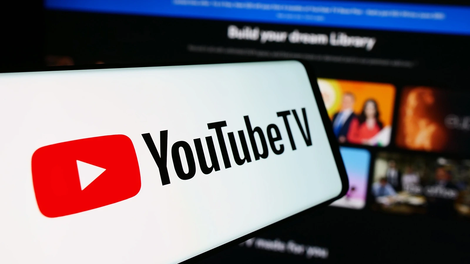 A smartphone displaying the YouTube TV logo with a blurred television screen in the background, illustrating the hidden YouTube TV discount deal.
