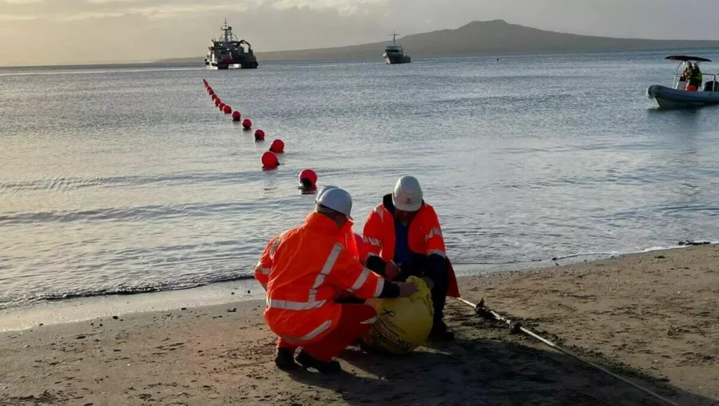 Workers laying undersea internet cables along the Red Sea shoreline, highlighting efforts after the Red Sea internet cable cut.