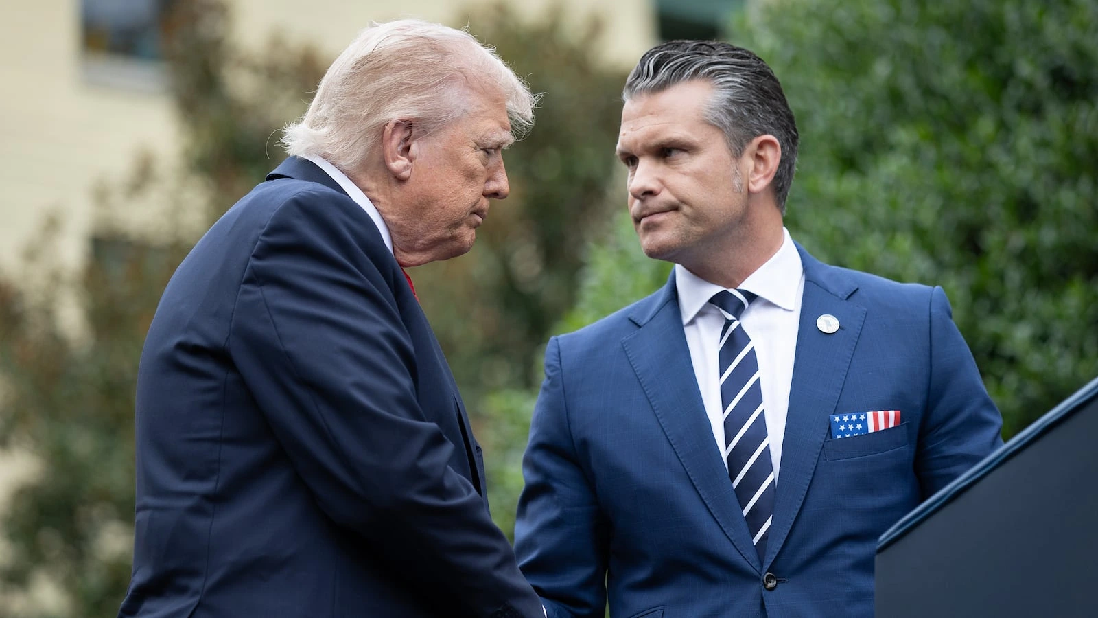 US Defence Secretary Pete Hegseth and President Donald Trump speaking at Marine Corps Base Quantico during a military summit focused on leadership and warrior ethos.