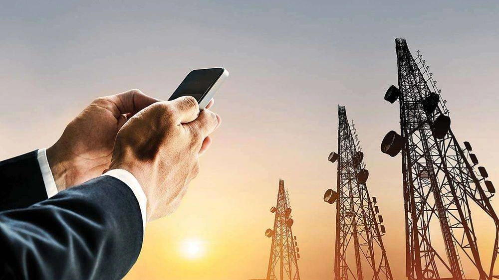 Businessman holding smartphone with telecom towers in background amid nationwide network shutdown Afghanistan telecom blackout