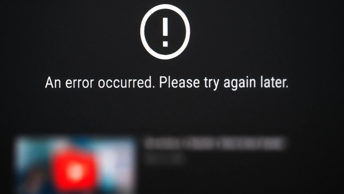 A blurred computer screen displaying a YouTube error message reading “An error occurred. Please try again later,” symbolizing the widespread YouTube outage affecting video playback.