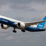 Boeing 777X aircraft taking off under cloudy skies, showcasing the jet’s blue and white livery and advanced widebody design.