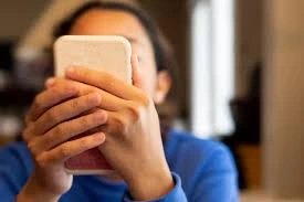 A teenage girl looks at her smartphone with concern, representing Meta AI parental controls allowing parents to disable private teen chats.