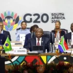 South African President Cyril Ramaphosa closing the G20 summit in Johannesburg with a gavel, while officials and delegates observe
