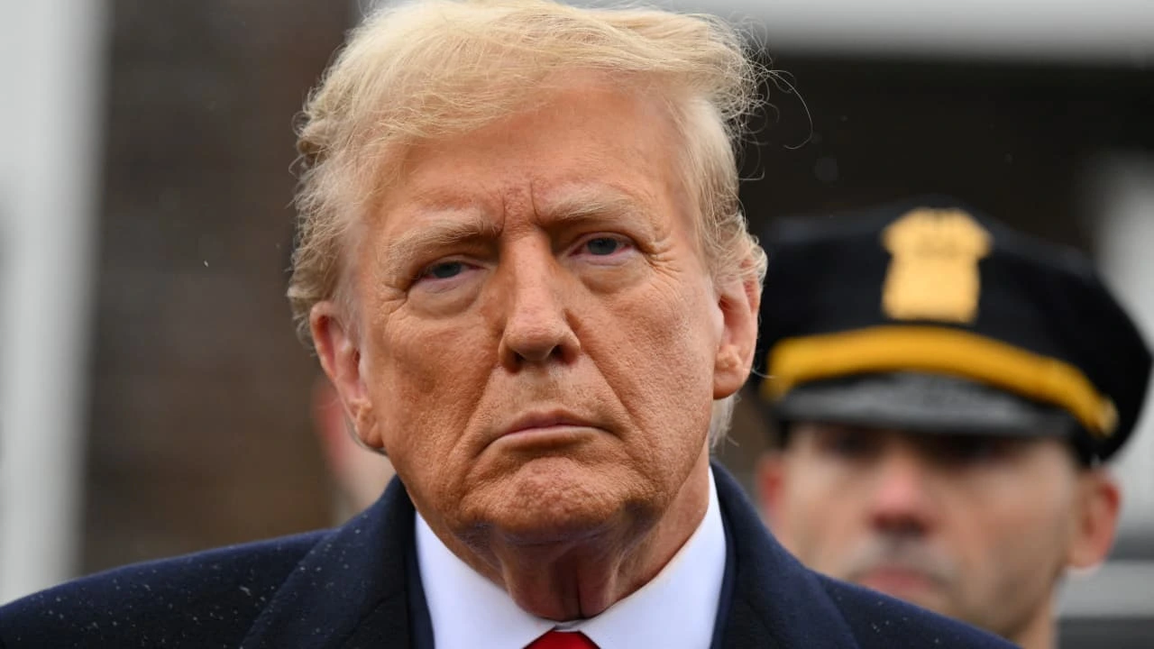 Trump looks at financial charts showing declining net worth, symbolizing his $1.1 billion drop in wealth