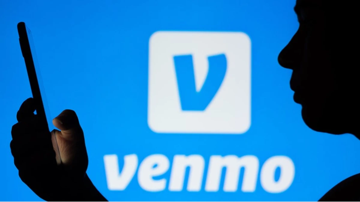 Frustrated woman looking at her phone during a Venmo outage as the payment app fails to load her transactions.