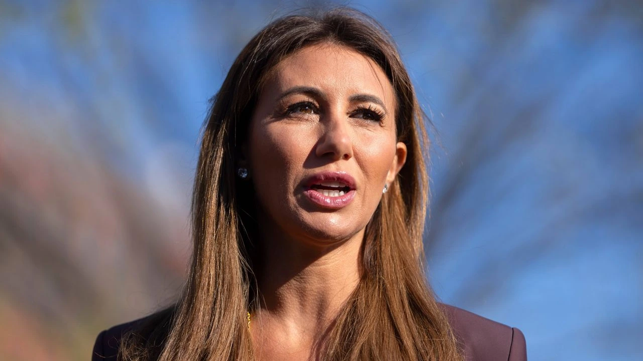 Alina Habba standing at a podium in a federal building after announcing her resignation as US attorney in New Jersey.