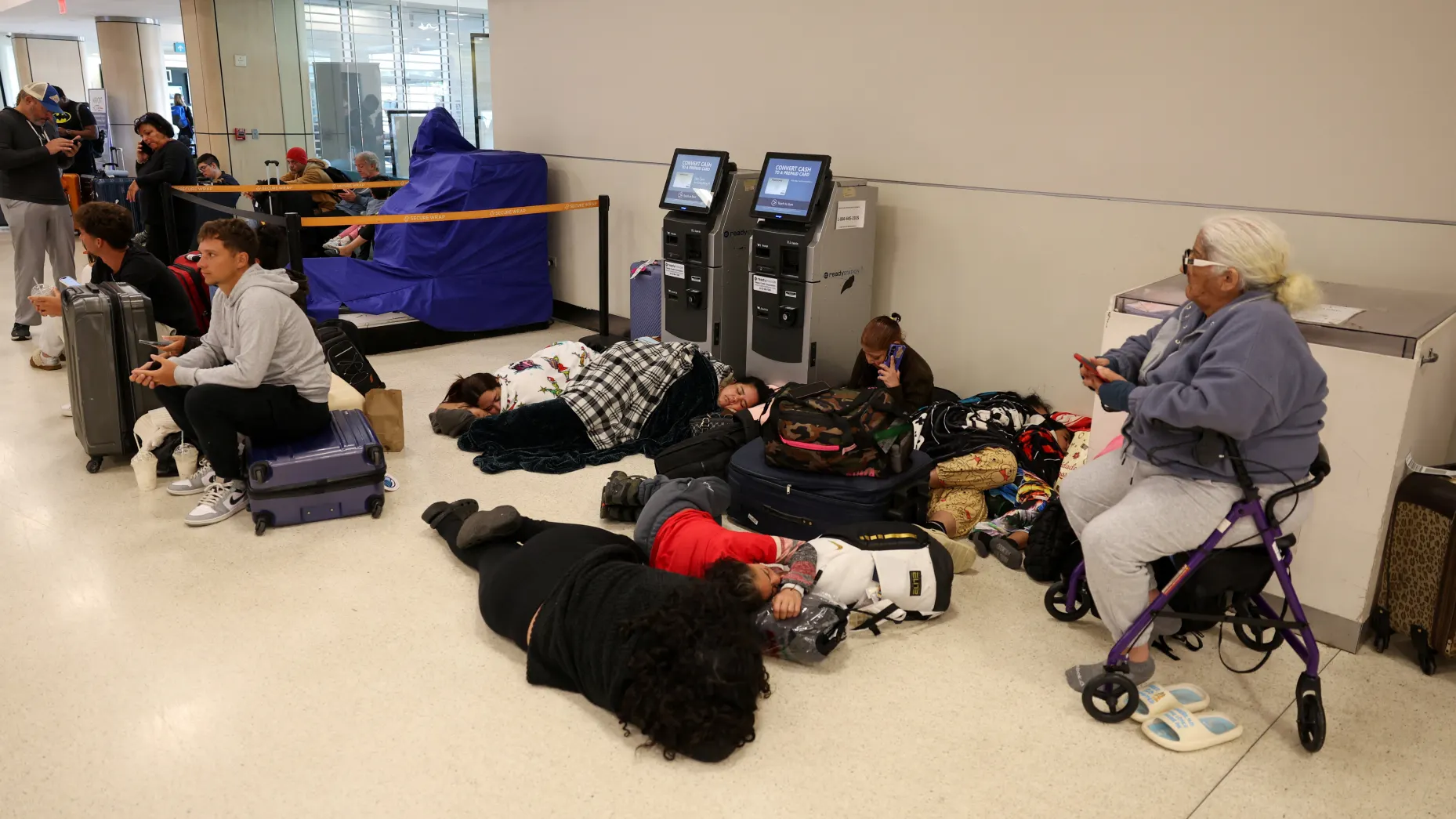 Passengers sleep on the floor, after flights were delayed and cancelled when the airspace was closed due to U.S. strikes on Venezuela overnight, at Rafael Hernandez International Airport in Aguadilla, Puerto Rico. REUTERS/Ricardo Arduengo