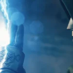 Doctor Doom raises a glowing armored hand as blue lightning crackles around his fingers in a dramatic scene from the Avengers: Doomsday trailer.
