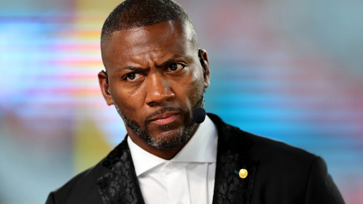 Ryan Clark appears on a television broadcast wearing a black suit and headset microphone during an ESPN studio segment.