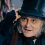 Johnny Depp as Ebenezer Scrooge in the first trailer for Ebenezer: A Christmas Carol, wearing a top hat and Victorian costume during the gothic holiday film.