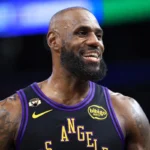 LeBron James smiles during an NBA game while wearing a Los Angeles Lakers jersey ahead of his reported move to the Philadelphia 76ers.