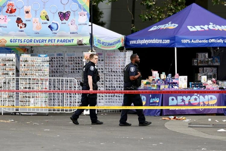 Seattle police officers investigate the scene of the Seattle festival shooting at Seattle Center after gunfire during the Bite of Seattle event left two people dead and five injured.
