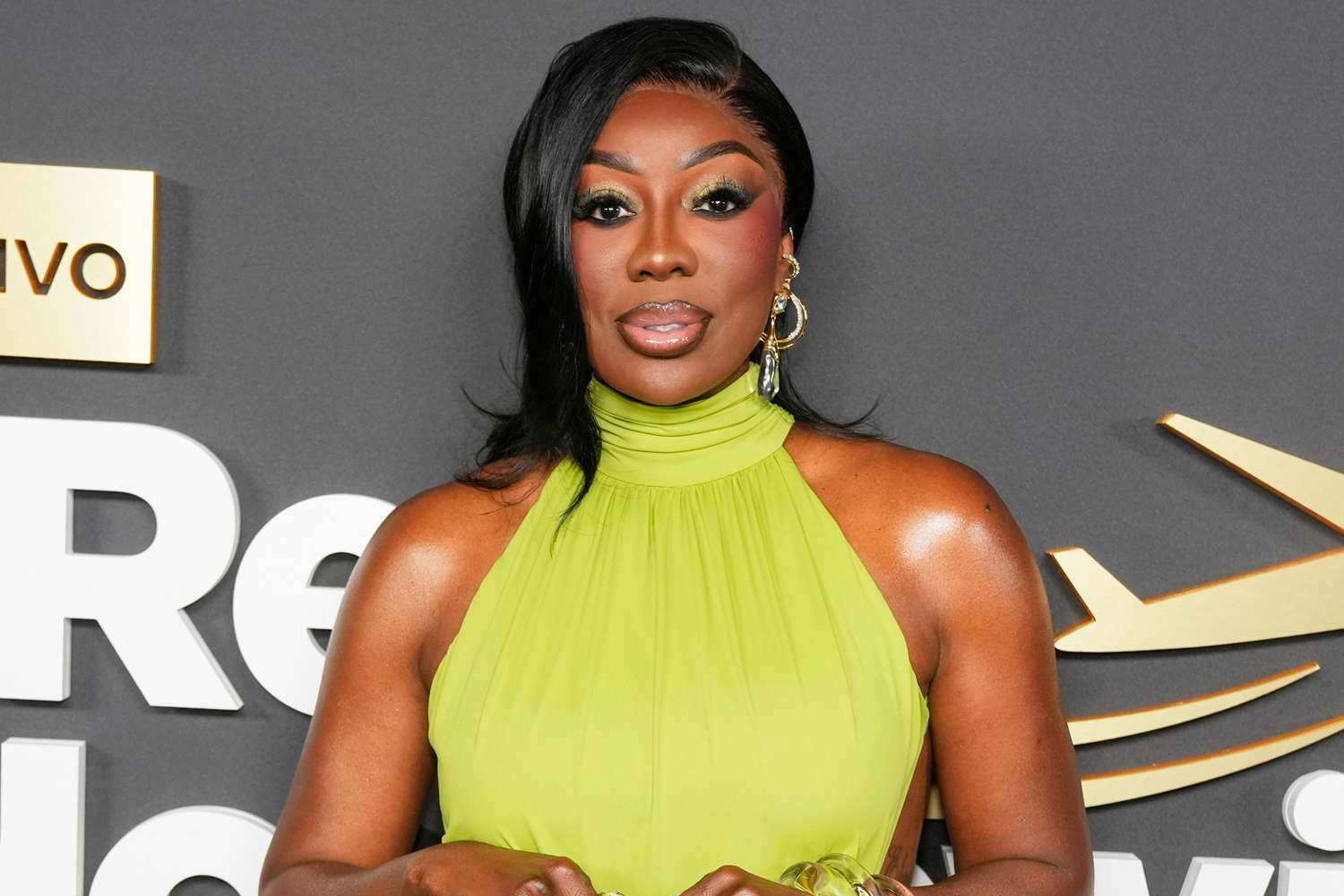 Wendy Osefo attends the Real Housewives Ultimate Girls Trip: Roaring 20th premiere in a lime green dress as she discusses filming The Real Housewives of Potomac season 11.